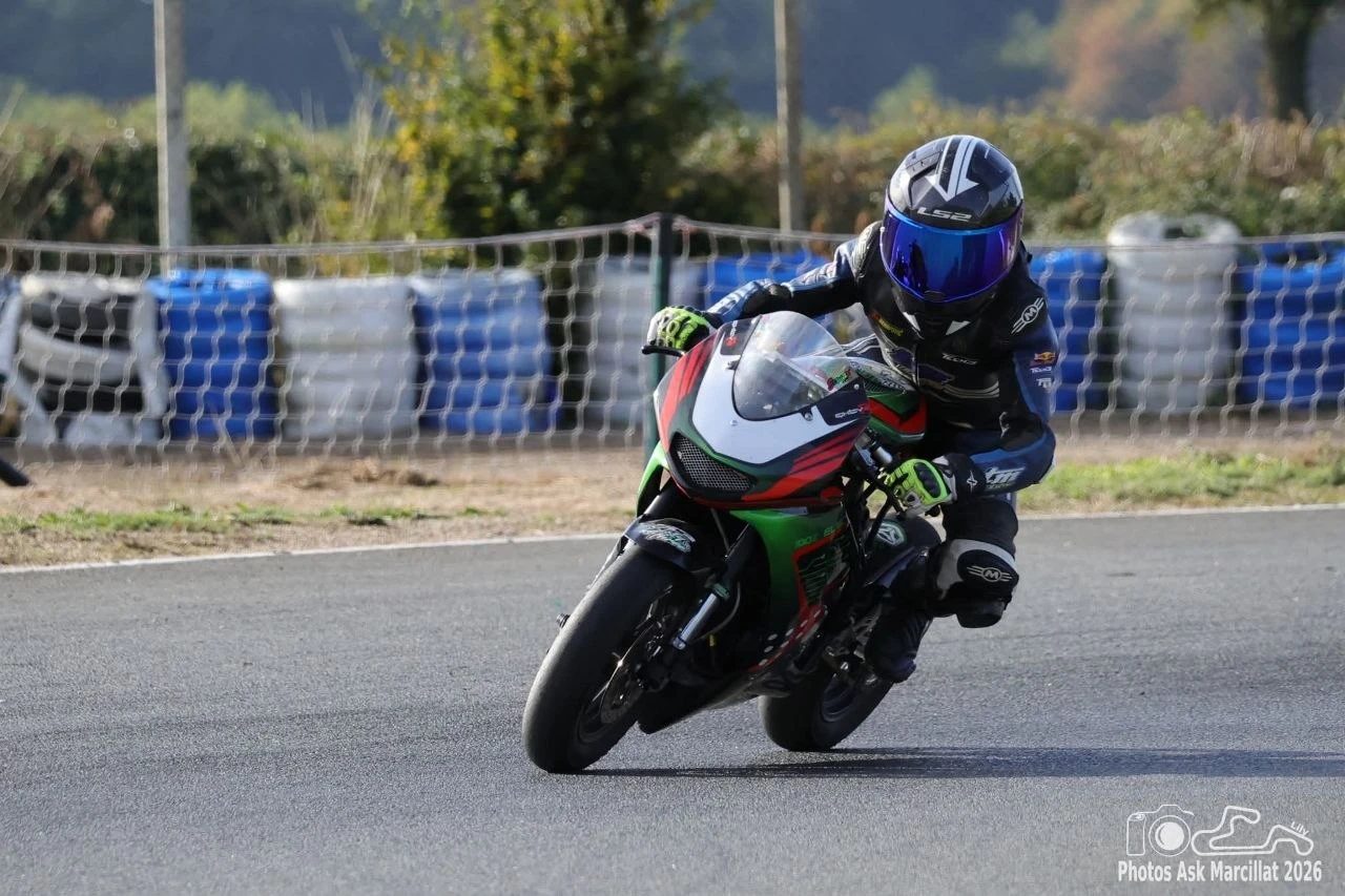 La FastBike Mini E en courbe sur circuit, pilote en combinaison et casque